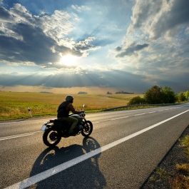 Person riding motorcycle on open road